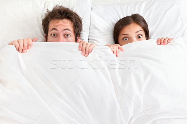 Funny Paar Bett schauen überrascht jungen Stock foto © Maridav