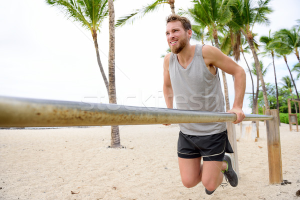 Bodyweight exercises man workout on dips bars Stock photo © Maridav