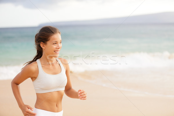 Athletic young woman running on the beach Stock photo © Maridav