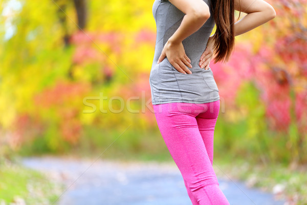 Back pain - running woman with back injury Stock photo © Maridav