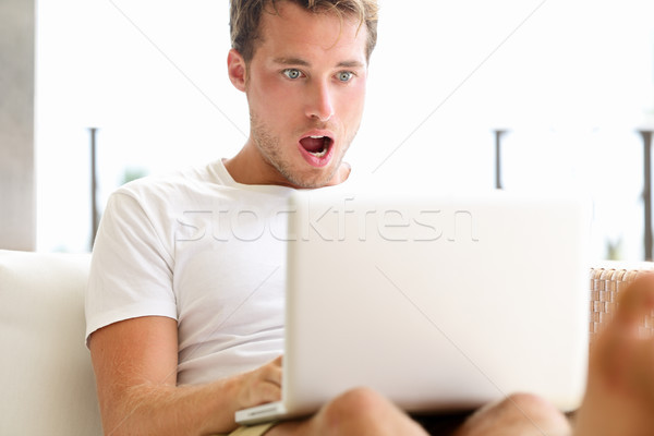 Zdziwiony człowiek patrząc laptop zdziwiony Zdjęcia stock © Maridav
