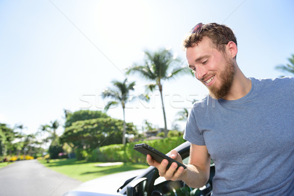 Car and smartphone app - man texting sms on phone Stock photo © Maridav