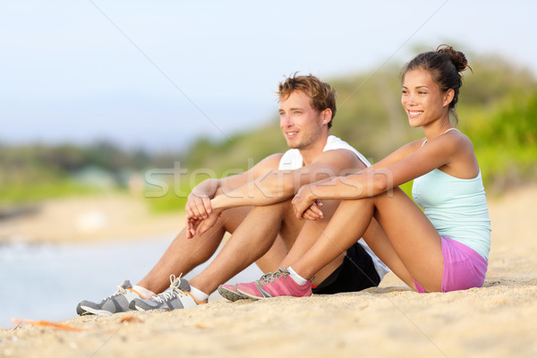 Sporty runners resting sitting before run on beach Stock photo © Maridav