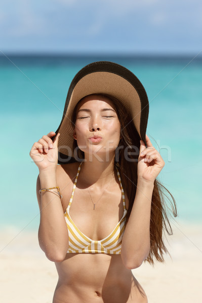Cute beach woman blowing a kiss with sun hat Stock photo © Maridav