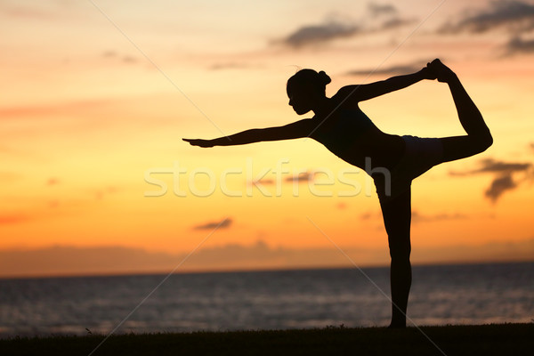 Yoga woman in serene sunset at beach doing pose Stock photo © Maridav