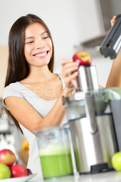 Stock photo: Woman making apple and vegetable juice on juicer
