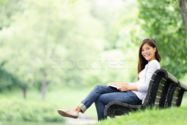 ストックフォト: 公園 · 女性 · 読む · ベンチ · 図書 · 笑みを浮かべて