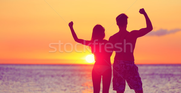 Happy fitness people on beach at sunset flexing Stock photo © Maridav