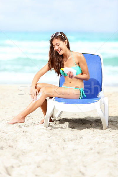 Woman on beach applying sunscreen lotion Stock photo © Maridav