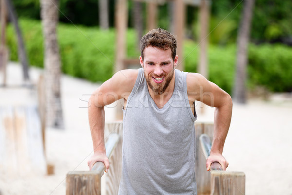 Fitness man doing dips at outdoor gym workout Stock photo © Maridav