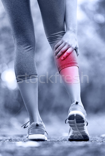 Stock photo: Muscle injury - woman running clutching calf muscle