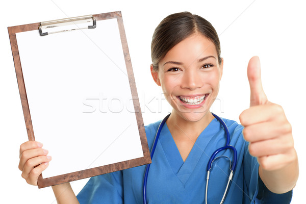 Stock photo: Nurse showing blank clipboard sign