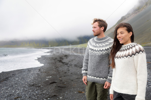 Iceland couple wearing Icelandic sweaters on beach Stock photo © Maridav
