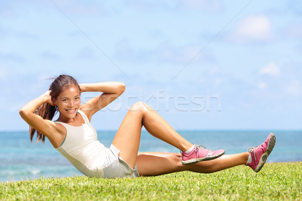 Exercising fitness woman doing sit ups outside Stock photo © Maridav