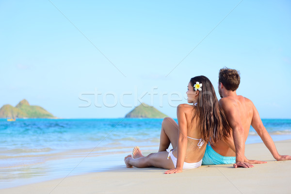 Hawaii vacation couple relaxing tanning on beach Stock photo © Maridav