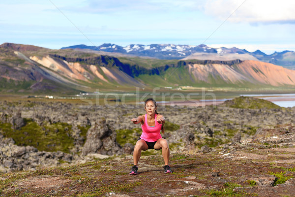 Fitness girl exercising outdoors doing jump squat Stock photo © Maridav