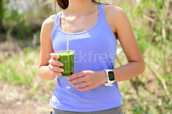 Green smoothie - woman runner wearing smartwatch Stock photo © Maridav