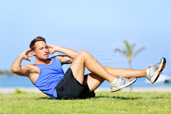 Sit ups - fitness man exercising sit up outside Stock photo © Maridav