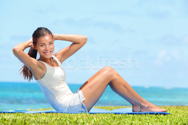 Fitness woman exercising doing sit ups outside Stock photo © Maridav