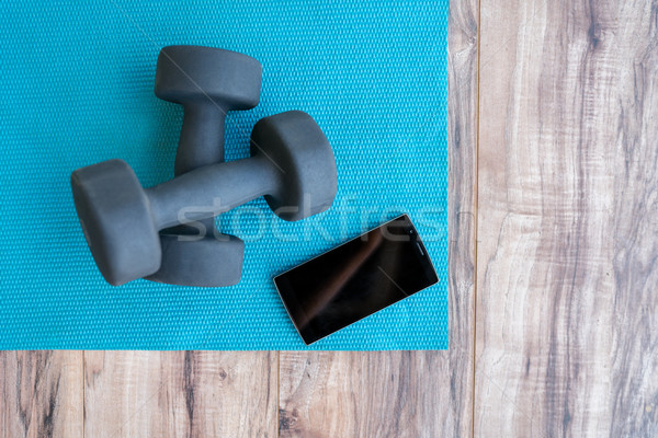 Fitness at home-weights yoga mat mobile phone app Stock photo © Maridav