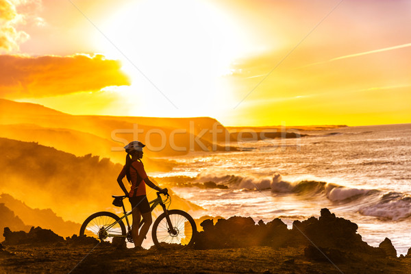 Mountain bike ciclista olhando pôr do sol ver mulher Foto stock © Maridav