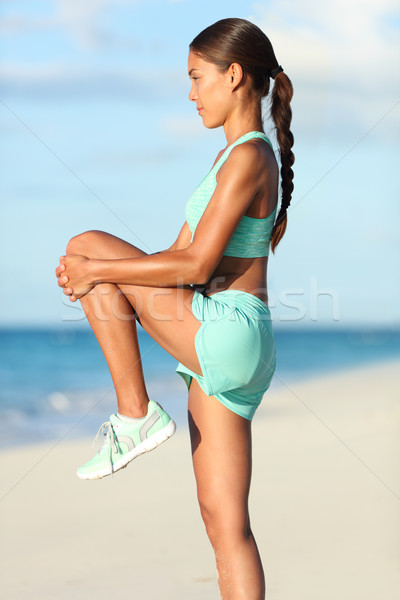 Fitness woman stretching leg muscles with standing knee to chest stretch Stock photo © Maridav