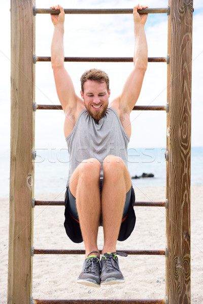 Fitness people - man training abs on cross fit bar Stock photo © Maridav