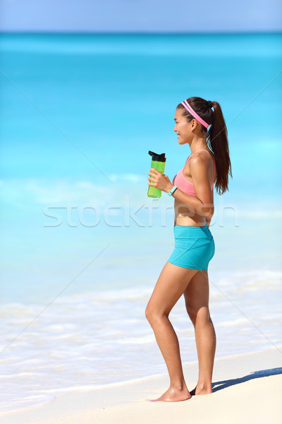 Beach runner taking running break drinking water Stock photo © Maridav