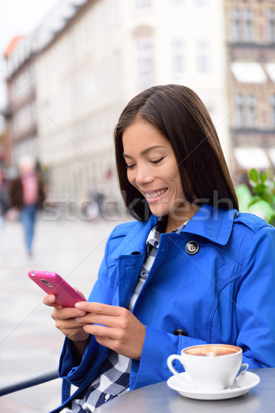 Asian woman texting on phone at outdoor cafe Stock photo © Maridav