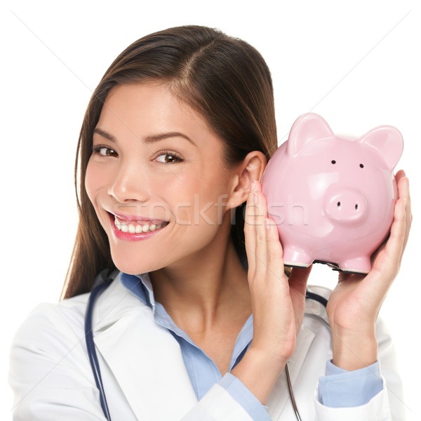 Healthcare concept - doctor holding piggy bank Stock photo © Maridav