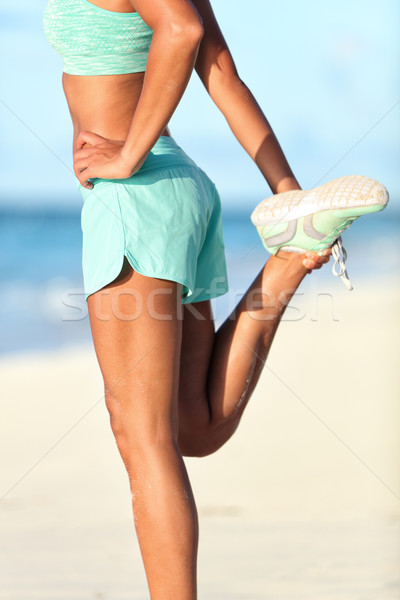 Female runner doing standing quadricep stretch running stretching exercise Stock photo © Maridav