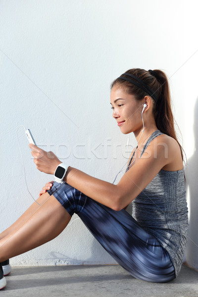 Fitness girl choosing motivation music listening to phone app and wearing  Stock photo © Maridav