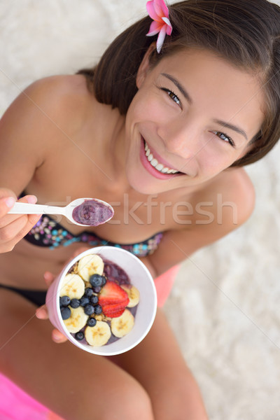 Acai bowl - woman eating healthy food on beach Stock photo © Maridav