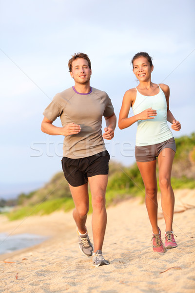 Running young couple jogging in beach sand happy Stock photo © Maridav