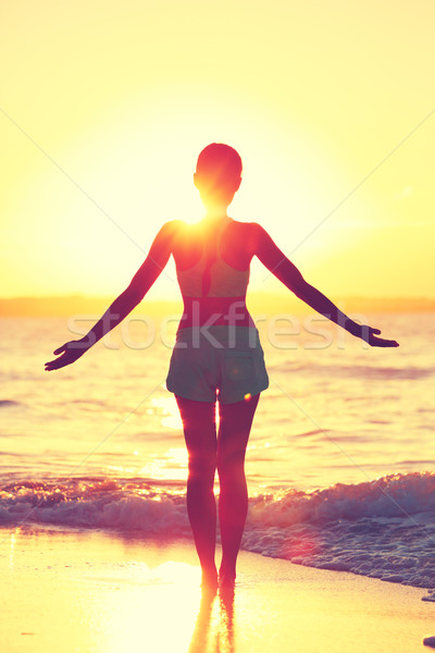 Mindfulness woman practicing yoga sun salutation at beach morning sunrise Stock photo © Maridav