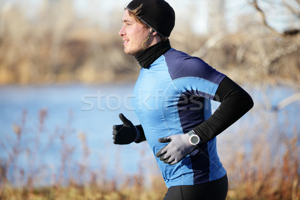 Runner man in fall running in autumn with gloves Stock photo © Maridav