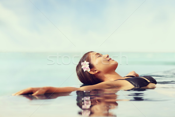 Luxury resort woman relaxing in infinity swim pool Stock photo © Maridav