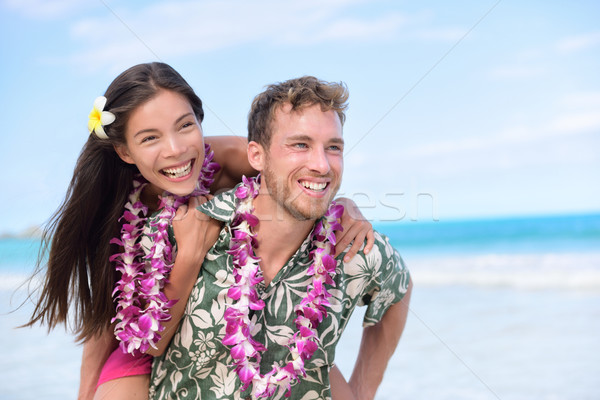 Happy beach couple having fun piggybacking Stock photo © Maridav