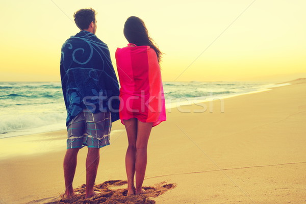 Romantic couple bathing with towels on beach sunset Stock photo © Maridav