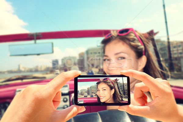 Taking pictures with smart phone of woman in car Stock photo © Maridav