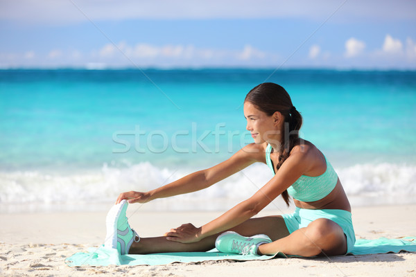 Fitness woman stretching legs on beach - Sporty Asian girl doing leg stretch  Stock photo © Maridav