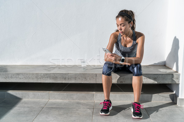 Fitness runner listening to music on mobile phone Stock photo © Maridav