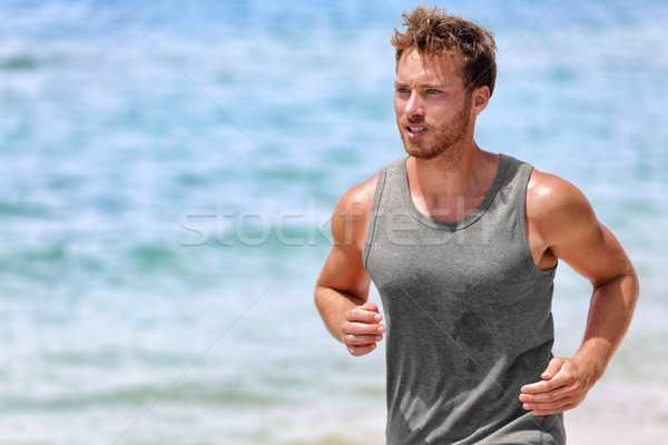 Active runner sweating running on summer beach Stock photo © Maridav