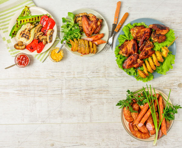 Ebédlőasztal választék étel sültcsirke szárnyak kolbászok Stock fotó © markova64el