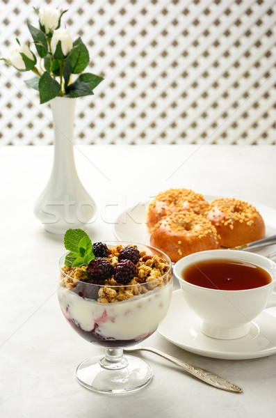 Stock photo: Breakfast of granola, buns brioche, honey and black tea .
