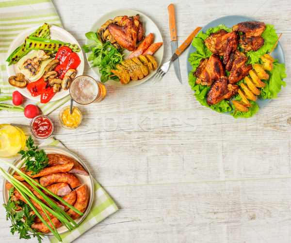Mesa de jantar variedade comida frango assado asas salsichas Foto stock © markova64el