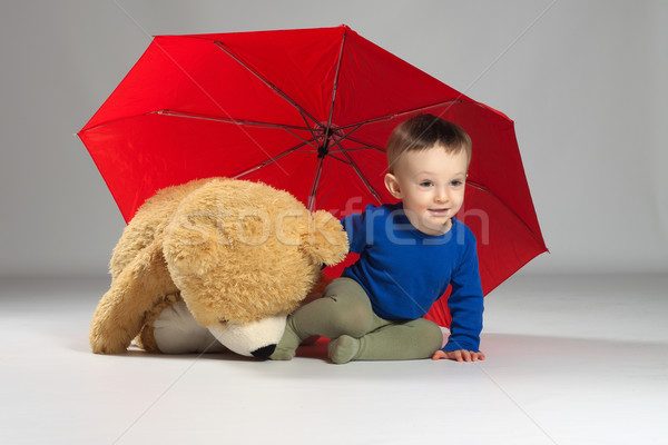 Młody chłopak chłopca posiedzenia czerwony parasol Zdjęcia stock © maros_b