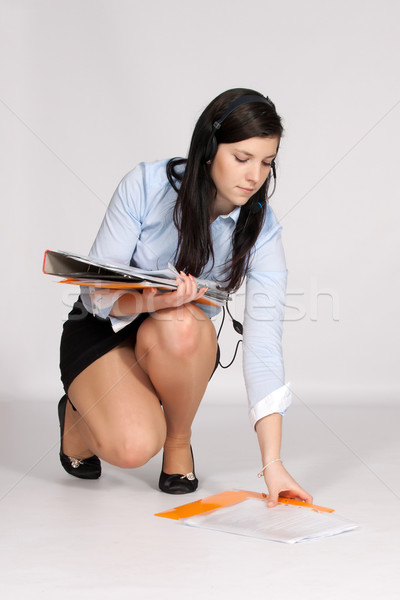 Young woman in mini skirt and blouse, squatting rises from the g Stock photo © maros_b