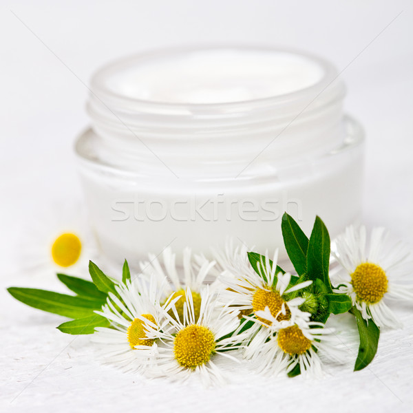 Stock photo: container with cream and chamomiles