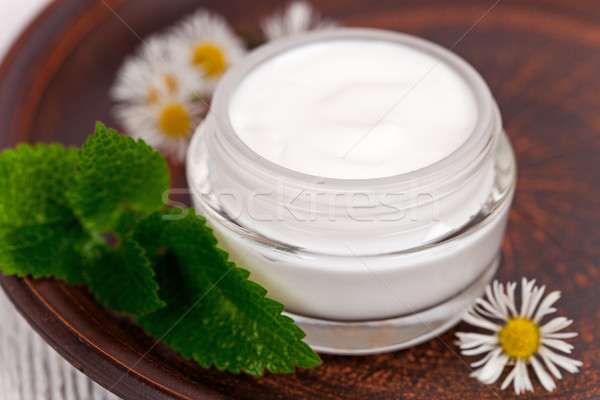 Stock photo: container with cream urtica and chamomiles